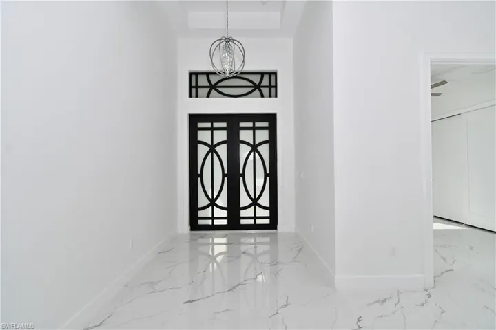Foyer entrance with french doors and a notable chandelier