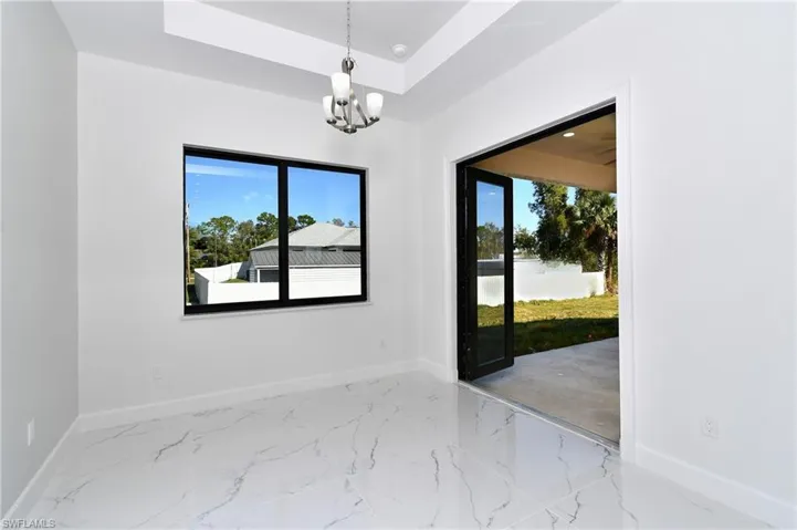 Unfurnished room with a chandelier and a tray ceiling