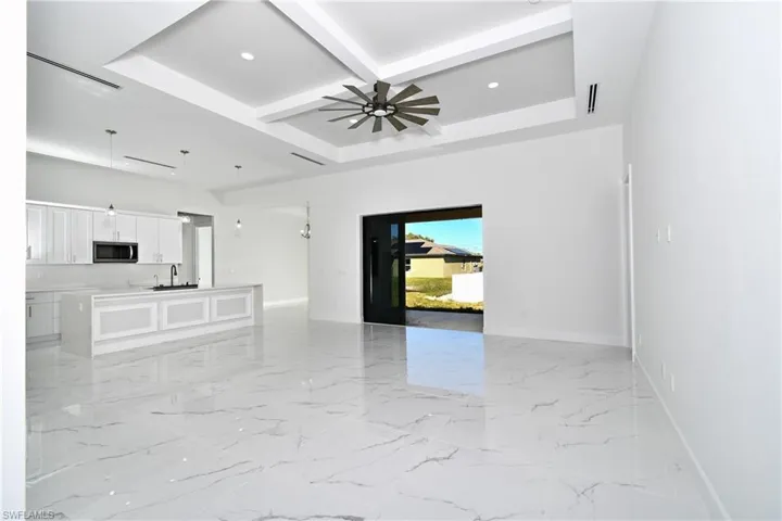 Unfurnished room with ceiling fan, beam ceiling, sink, and coffered ceiling