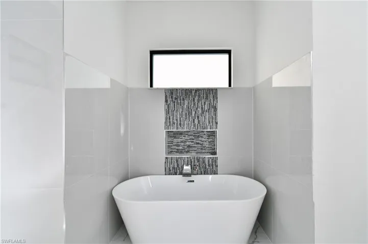 Bathroom featuring a bathing tub and tile walls