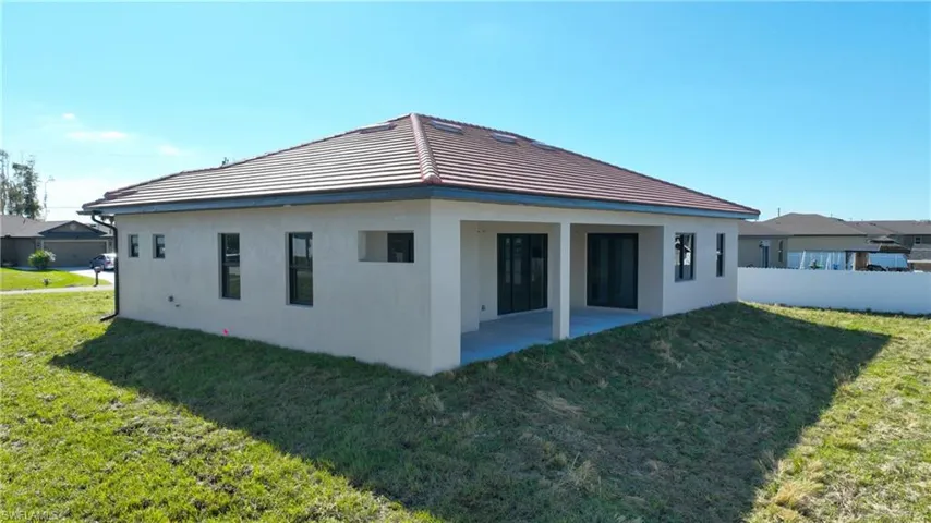 View of side of home featuring a patio area and a yard