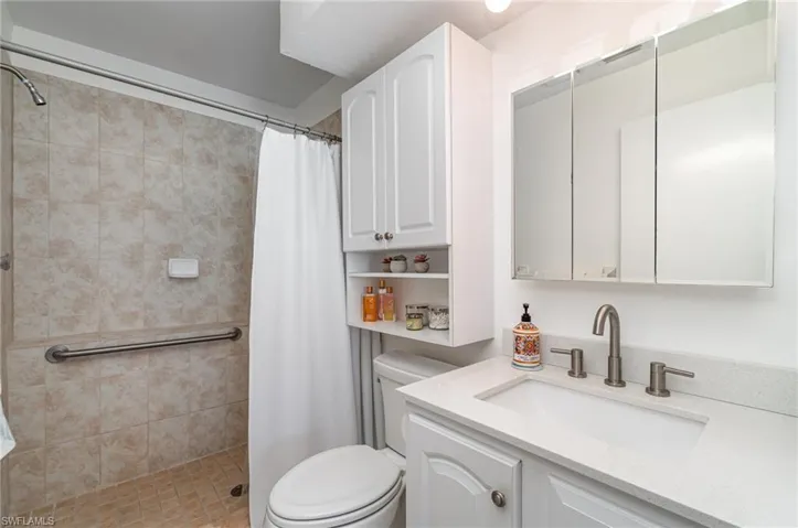 Bathroom featuring quartz counter and easy step-in shower