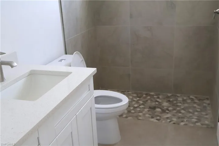 Bathroom featuring vanity, toilet, and walk in shower