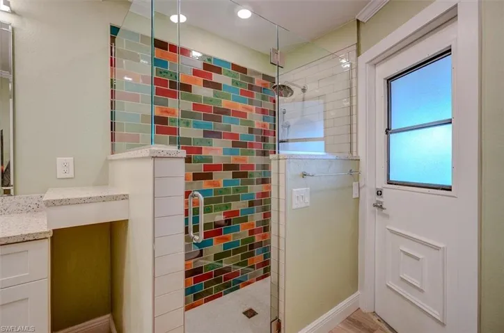 Bathroom with a shower with door, vanity, and hardwood / wood-style flooring