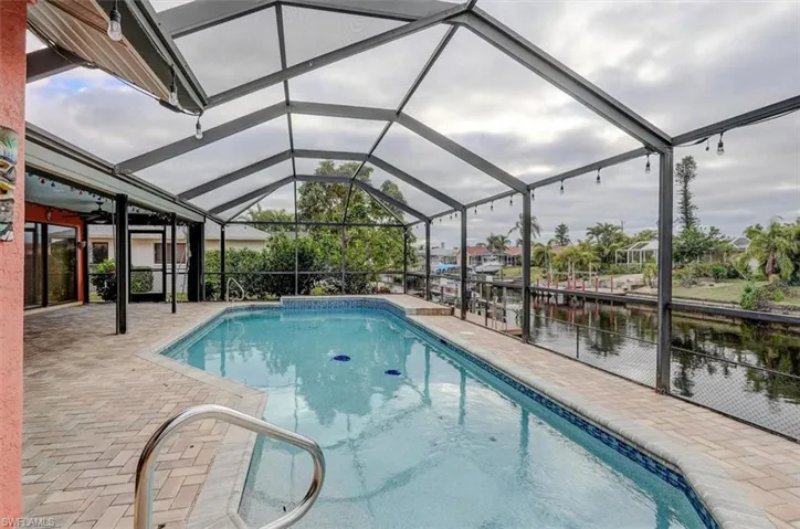 View of pool featuring a lanai, a water view, and a patio