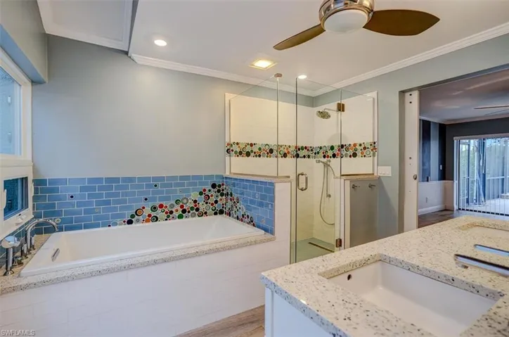 Bathroom featuring ornamental molding, vanity, independent shower and bath, and hardwood / wood-style floors