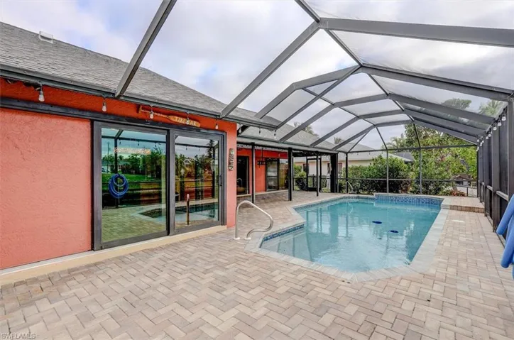 View of pool with a patio and glass enclosure