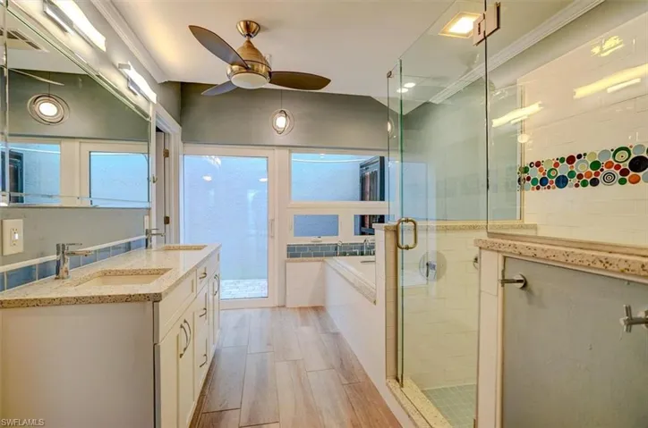 Bathroom with ceiling fan, crown molding, vanity, independent shower and bath, and hardwood / wood-style flooring