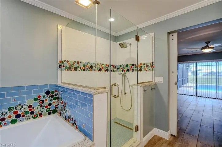Bathroom featuring hardwood / wood-style floors, separate shower and tub, ceiling fan, and crown molding