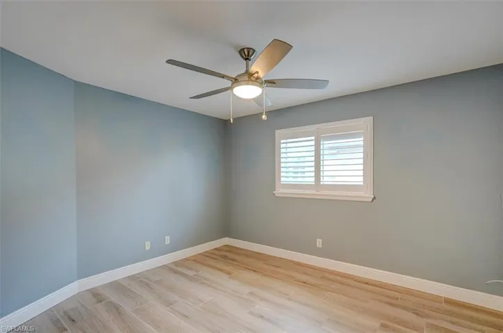 Unfurnished room with light hardwood / wood-style floors and ceiling fan