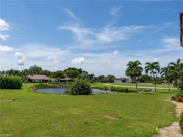 View of community featuring a lawn and a water view