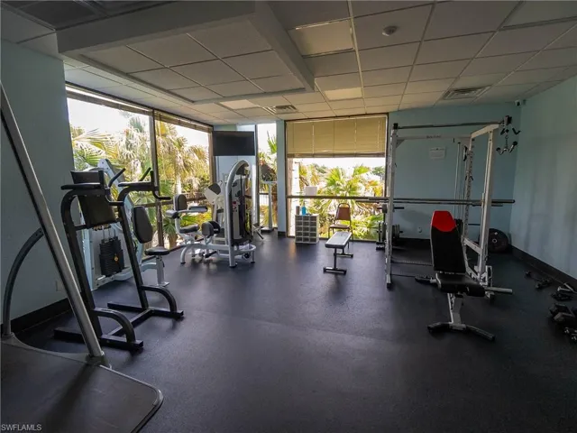 Workout area featuring floor to ceiling windows and a paneled ceiling
