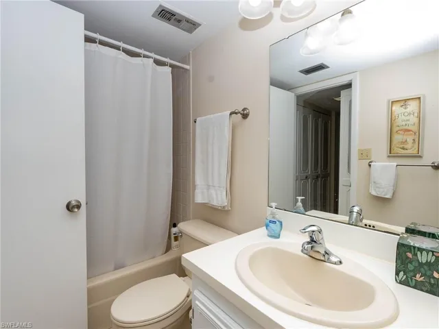Full bathroom with shower / bath combination with curtain, vanity, and toilet
