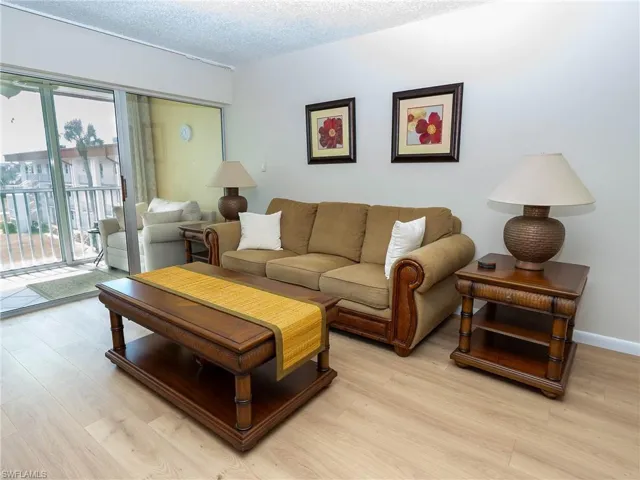 Living room with a textured ceiling and light hardwood / wood-style floors