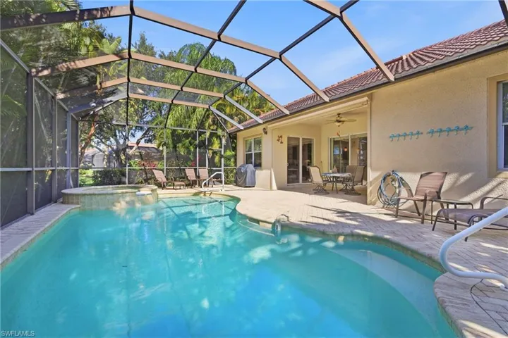 View of swimming pool with a patio, glass enclosure, a pool with connected hot tub, a sunroom, and a grill