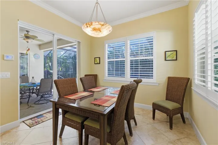 Dining room with crown molding, plenty of natural light, light tile patterned flooring, a sunroom, and a ceiling fan