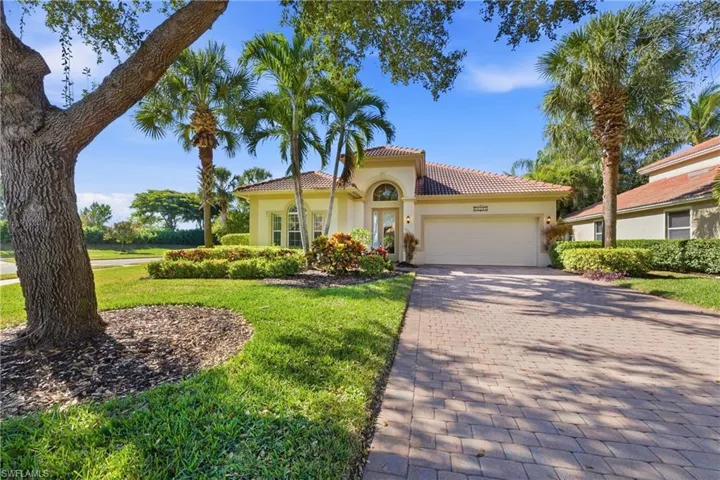 Mediterranean / spanish home with decorative driveway, a tiled roof, stucco siding, a garage, and a front yard