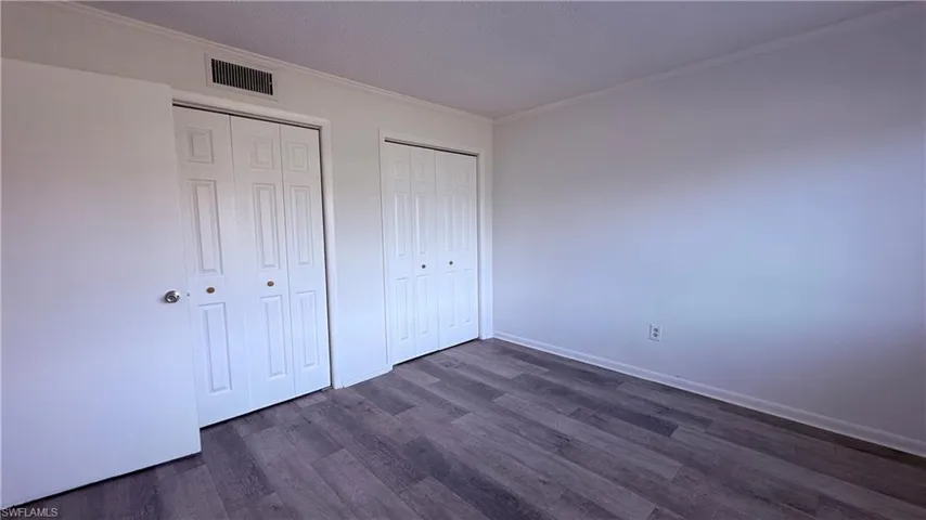 Room featuring wood-finish flooring, white walls, and white trim