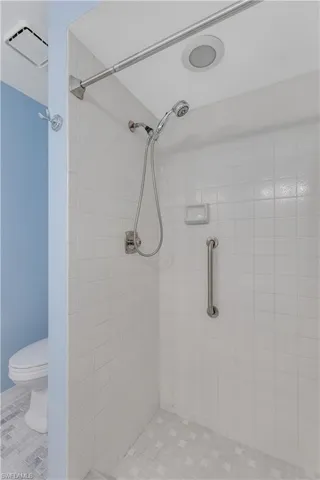 Bathroom with tiled shower and toilet