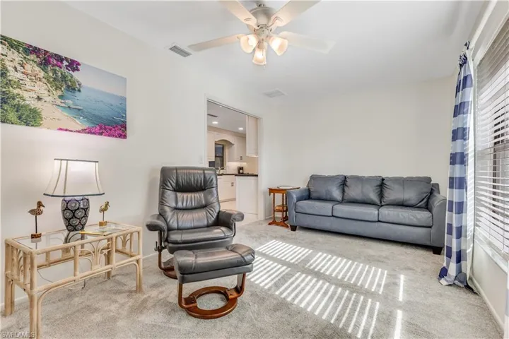 Carpeted living room featuring ceiling fan and a healthy amount of sunlight