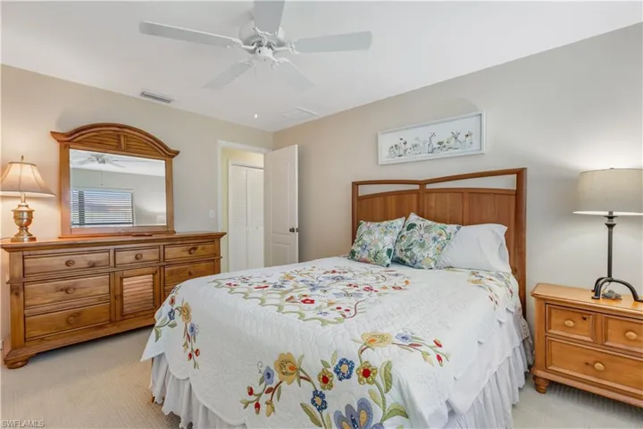Carpeted bedroom featuring ceiling fan and a closet