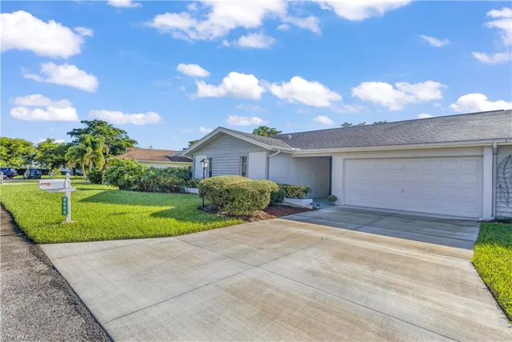 Single story condo home with a front lawn and a garage