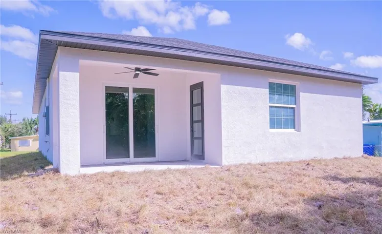 Rear view of property featuring a ceiling fan and stucco siding