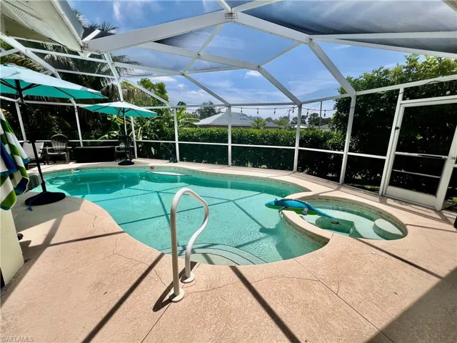 Screen enclosed in ground pool/spa combo with large covered patio for entertaining.