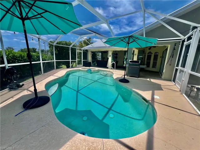 Screen enclosed in ground pool/spa combo with large covered patio for entertaining.
