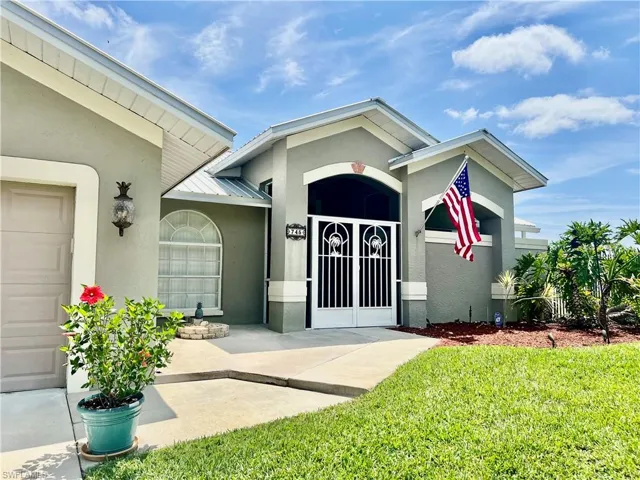 Property entrance featuring metal roof, a yard, and stucco siding