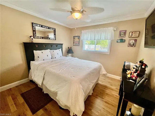 Guest bedroom featuring crown molding, and light wood-style flooring