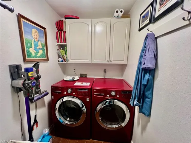 Full size washer and dryer in laundry room with extra cabinet space