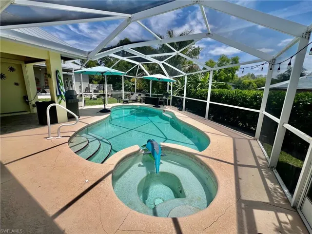 Screen enclosed in ground pool/spa combo with large covered patio for entertaining.