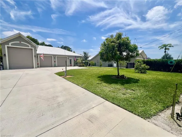 Detached garage and front yard with Roth iron fencing.