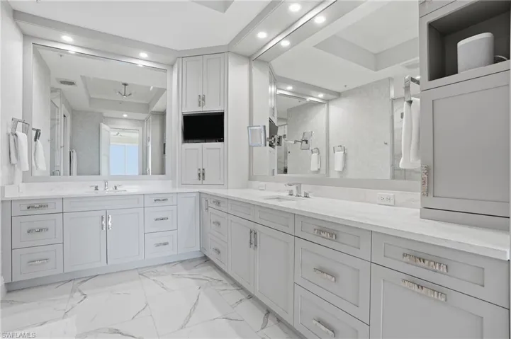 Dual vanities, extra cabinetry, and a built in television.