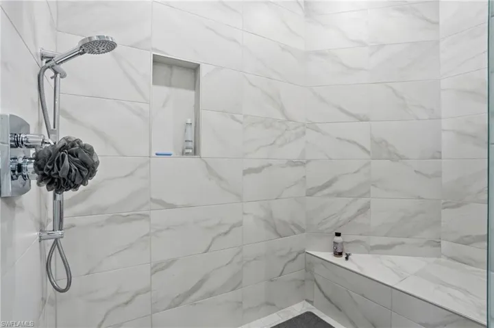Spacious walk in shower with built-in bench.