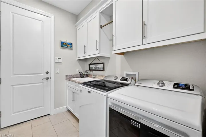 Laundry room featuring cabinet space, utility sink and separate washer and dryer