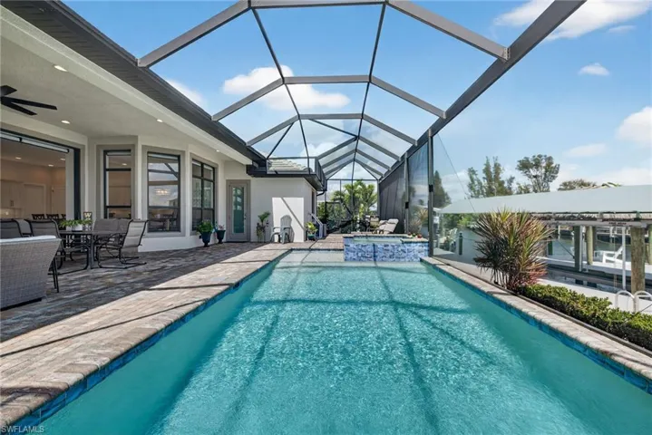 Relaxing pool / spa featuring outdoor dining and lounging areas, all overlooking the canal