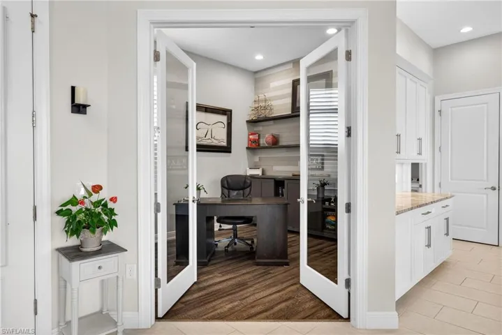Office area with a custom wall with built in cabinets, french doors, light wood-style flooring, and recessed lighting