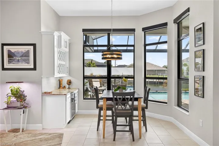 Dining space featuring wine bar and wine cooler, and overlooking the pool and canal
