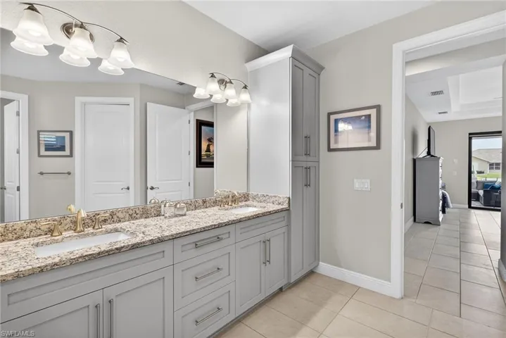 Full bathroom featuring double vanity, a garden tub, a shower stall, and light tile patterned floors