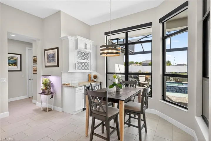 Dining space featuring wine bar and wine cooler, and overlooking the pool and canal