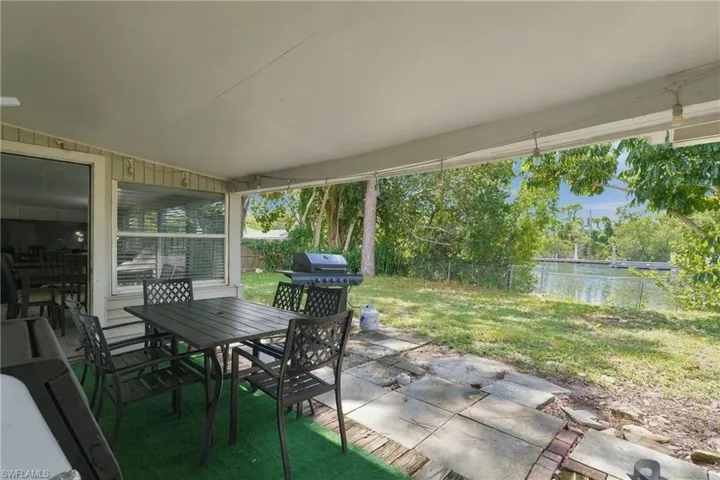Covered patio featuring a concrete slab surface, exterior siding, and direct water access