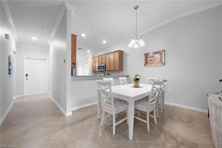 Dining room featuring a chandelier, crown molding, and recessed lighting
