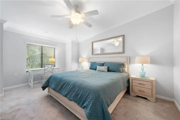 Bedroom with crown molding, carpet flooring, and a ceiling fan