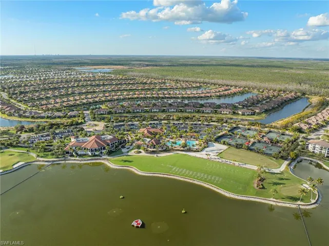 Aerial perspective of suburban area featuring a nearby body of water and a golf club