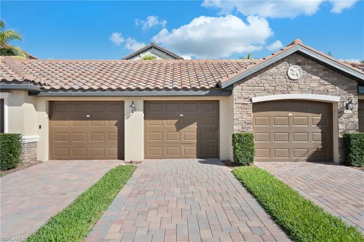 View of front of property with stucco siding, a tiled roof, and stone siding