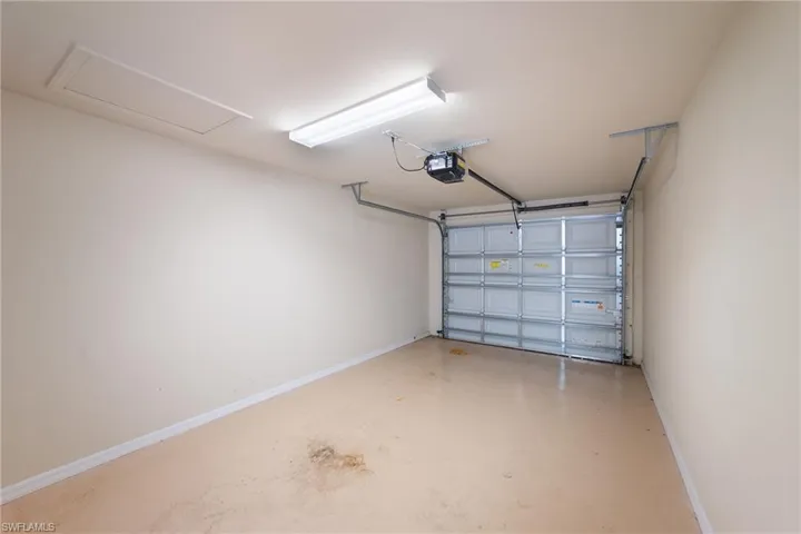 Garage featuring baseboards and a garage door opener