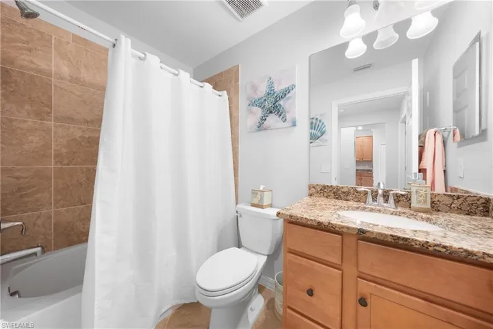 Full bath with vanity and shower / bath combination with curtain