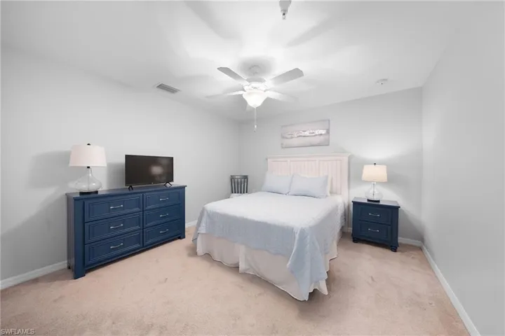 Bedroom with light carpet and a ceiling fan